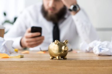 depositphotos-182064934-stock-photo-selective-focus-piggy-bank-businessman